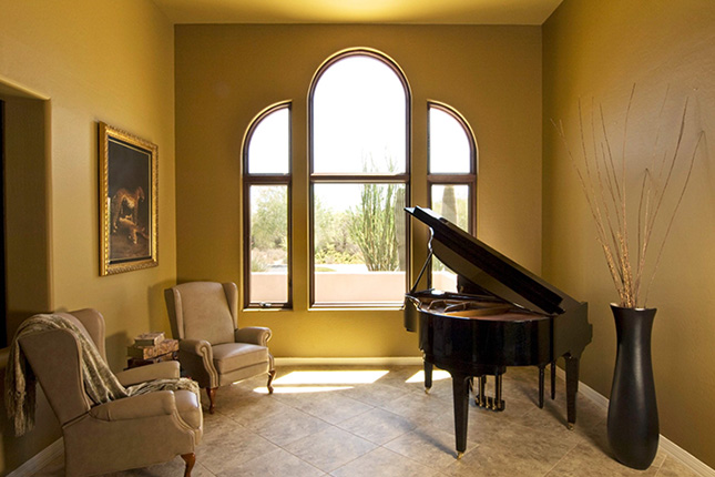 Specialty window next to a piano.