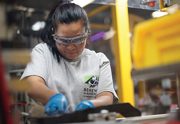 Factory worker building windows.